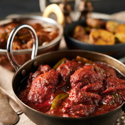 Naga chicken tikka curry in a carbon steel Indian styled bowl from the front.