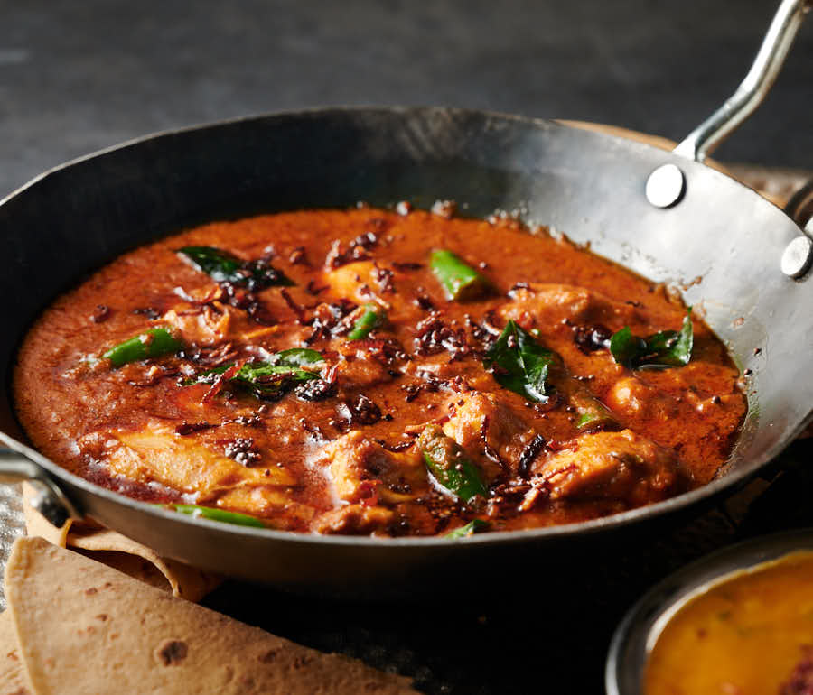 Garnished Kerala chicken curry in a Balti bowl from the front