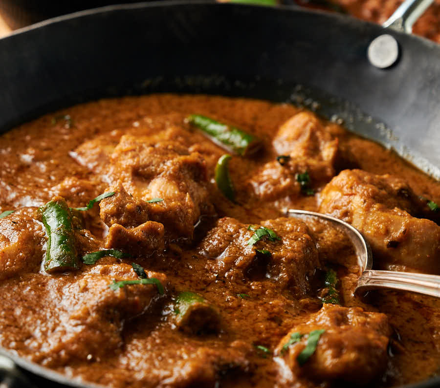 Hariyali chicken curry close-up with serving spoon from the front.