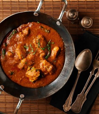 achari chicken curry in a kadai from above.