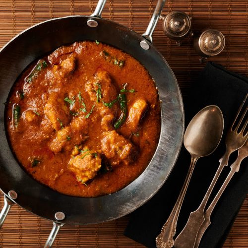 achari chicken curry in a kadai from above.