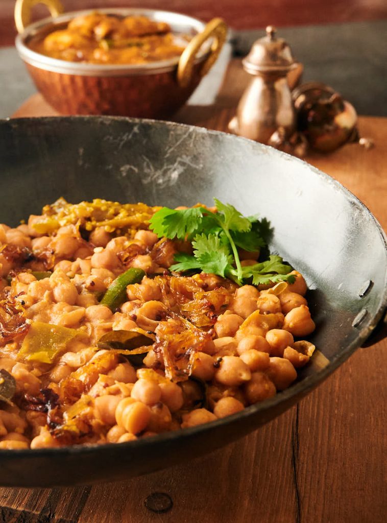 Serving bowl of green chili chana achari from the front.